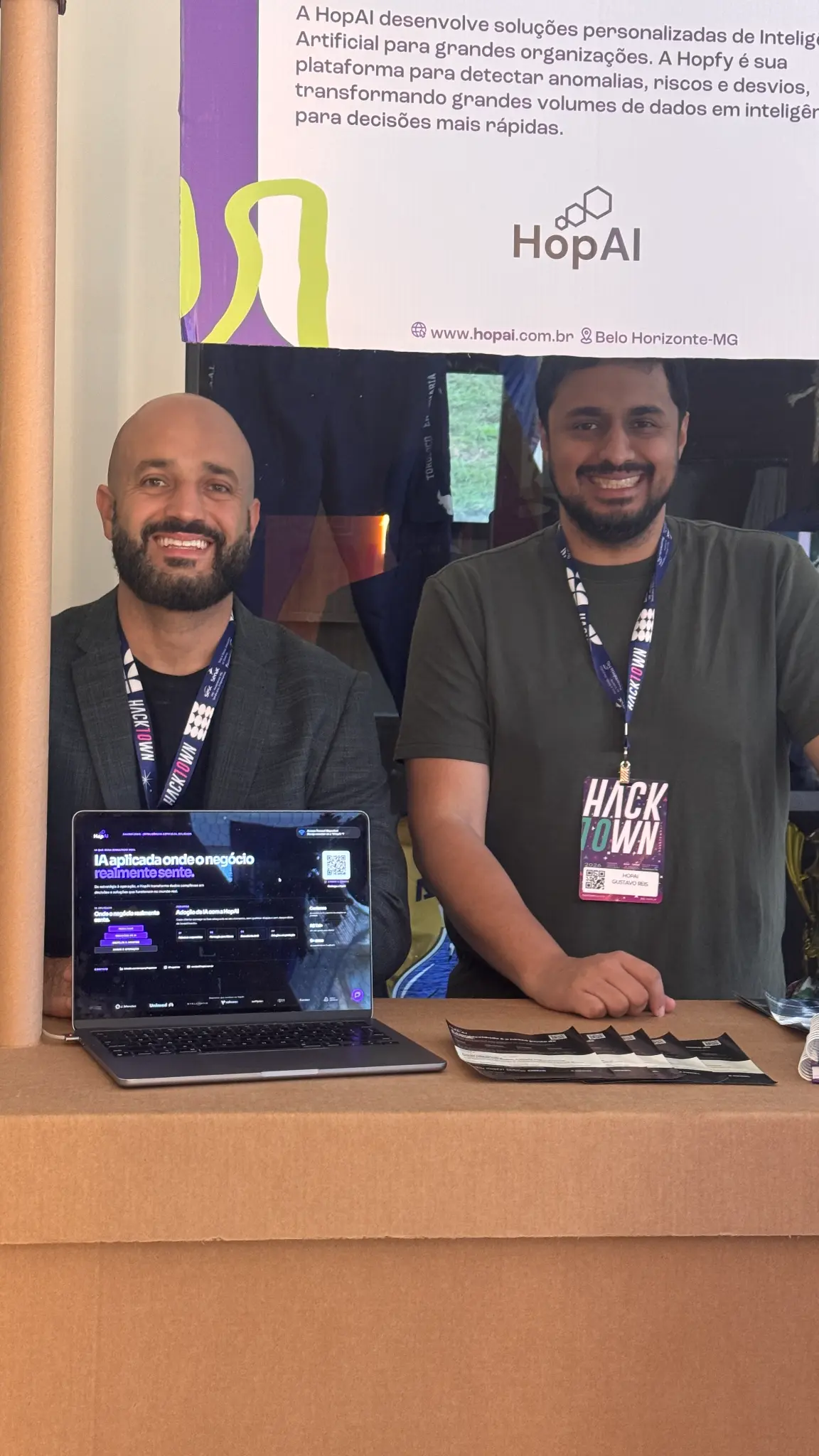 Hugo Azevedo, CEO da HopAI, e Gustavo Reis, Diretor de IA da HopAI, no estande da empresa durante o HackTown 2026.